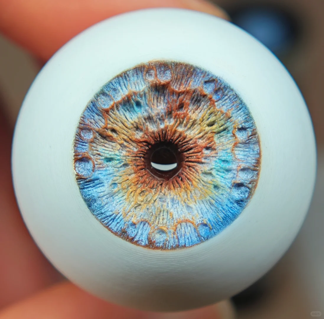 Detailed custom BJD eyes showing carved irises, color, and reflective finish